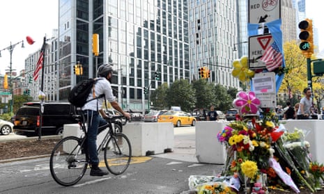 Man on bike cycles past flowers left for victims of the attack