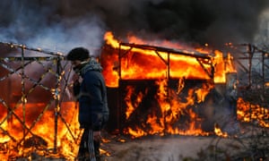 Shelters at the Calais refugee camp ablaze at the start of the clearing operation.