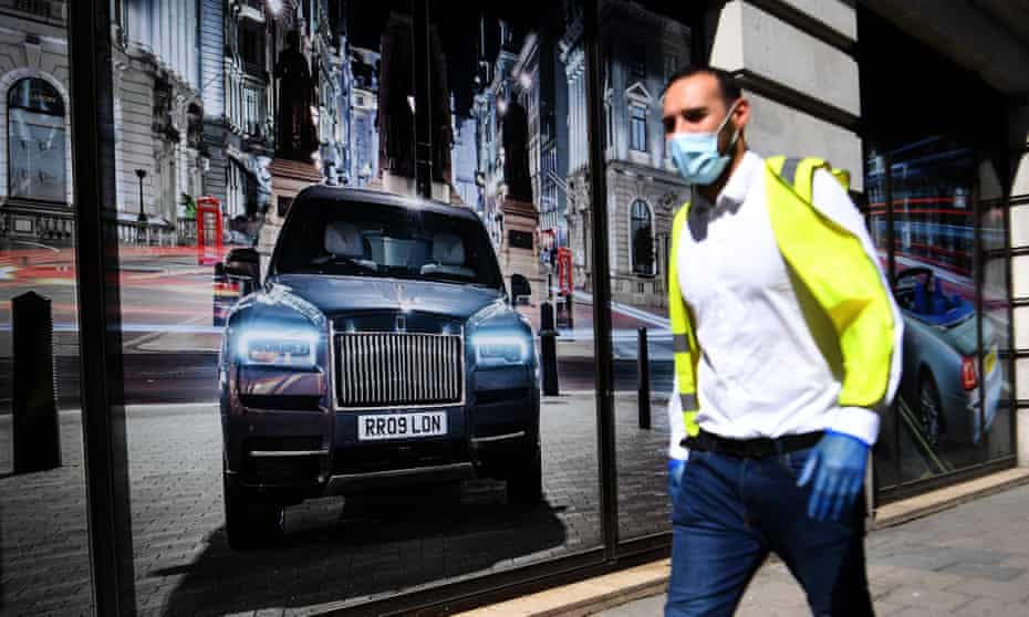 A pedestrian passes a Rolls-Royce showroom in London