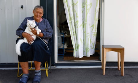 A woman sits with her cat outside a home in a ‘container towns’ for internally displaced Ukrainians in Lviv, Ukraine.