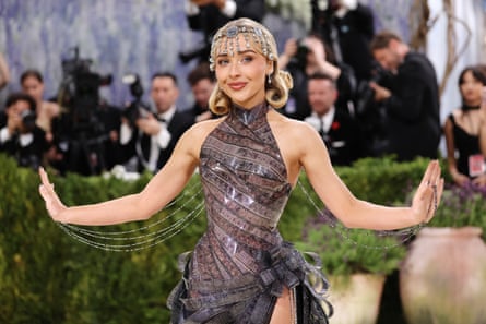 Sabrina Carpenter poses in her costume dress made out of film from the film Sabrina.