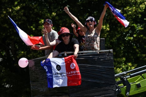Spectators cheer from the bucket of a cherry-picker.