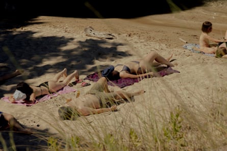 Tourists sunbathe on Voidokilia beach