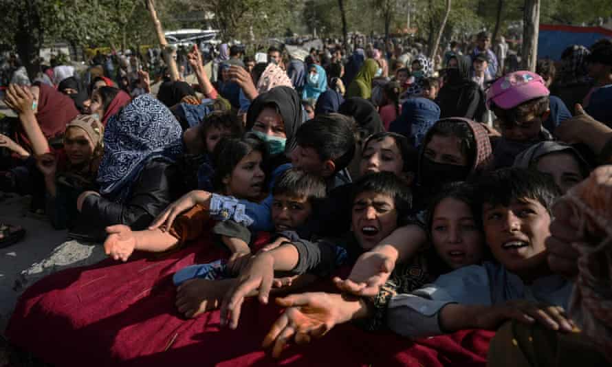 Taliban capture sixth provincial capital in northern Afghanistan | Afghanistan 1 Afghan families that fled from Kunduz and Takhar provinces wait to collect food in Kabul