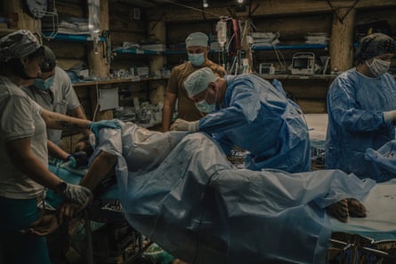 Surgeons operate on a wounded soldier at an underground hospital
