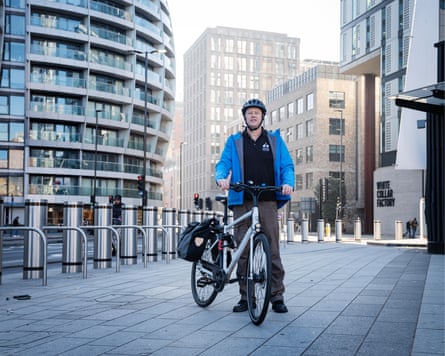 Tom Fyans, London Cycling Campaign CEO, stands with his bicycle on a city pavement
