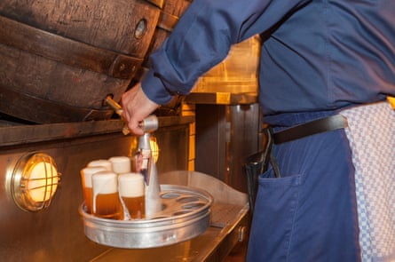 A closeup of beer being poured into stangen in a kranz