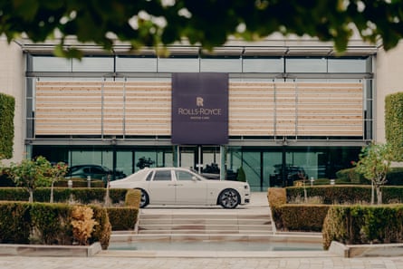 A white Rolls-Royce Phantom parked outside the Rolls-Royce factory building