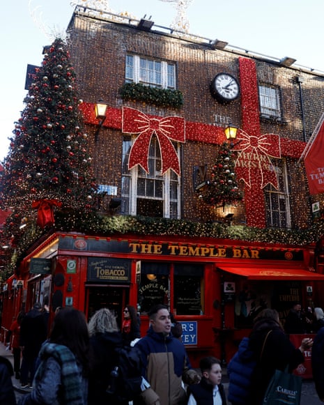Shoppers walk past Christmas decorations in Temple Bar