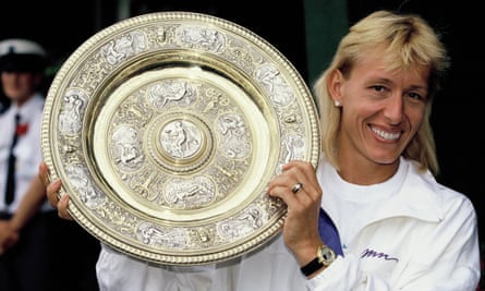 Martina Navratilova shows off her Wimbledon trophy in 1990.