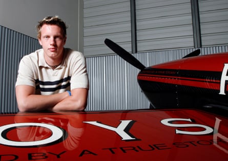 man poses with arms folded against plane