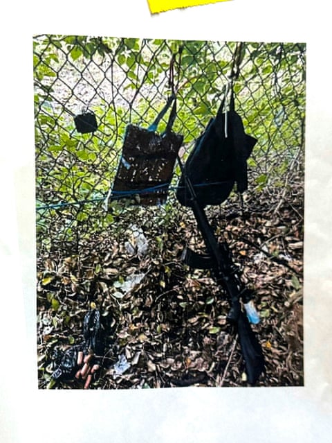 photo of photo showing two backpacks and firearm in front of fence and grass