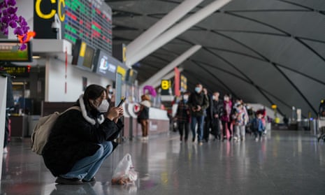 A woman wearing a face mask uses her cellphone at Nanning Wuxu International Airport in Nanning, Guangxi Zhuang Autonomous Region, China, 18 January 2023. 