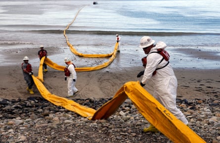 people cleaning up a oil spill