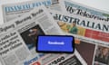 Phone screen with Facebook logo and Australian newspapers