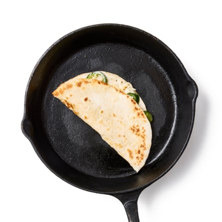 Folded quesadilla on a heavy saucepan.