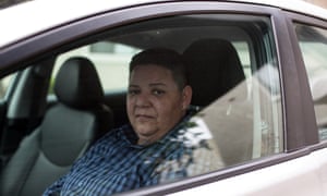 Rebecca Graham, who has stopped working for Uber, sits in her car that she uses to drive for competitor Lyft.