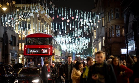 Shoppers and pedestrians pass under the Christmas lights on Oxford Street, London, in November 2022.