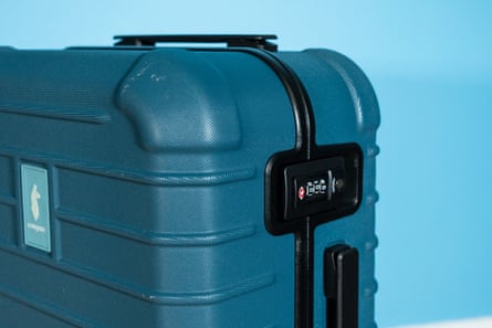 Closeup of a teal suitcase in front of blue wall