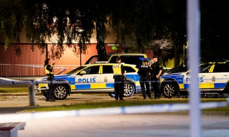 Swedish police officers and cars at the scene of a shooting.