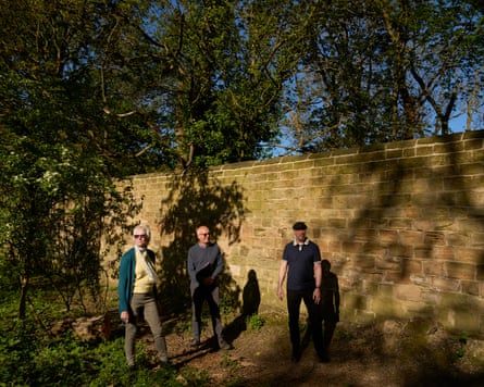 Barbara Phipps, John Smith and John Whitaker in front of the wall