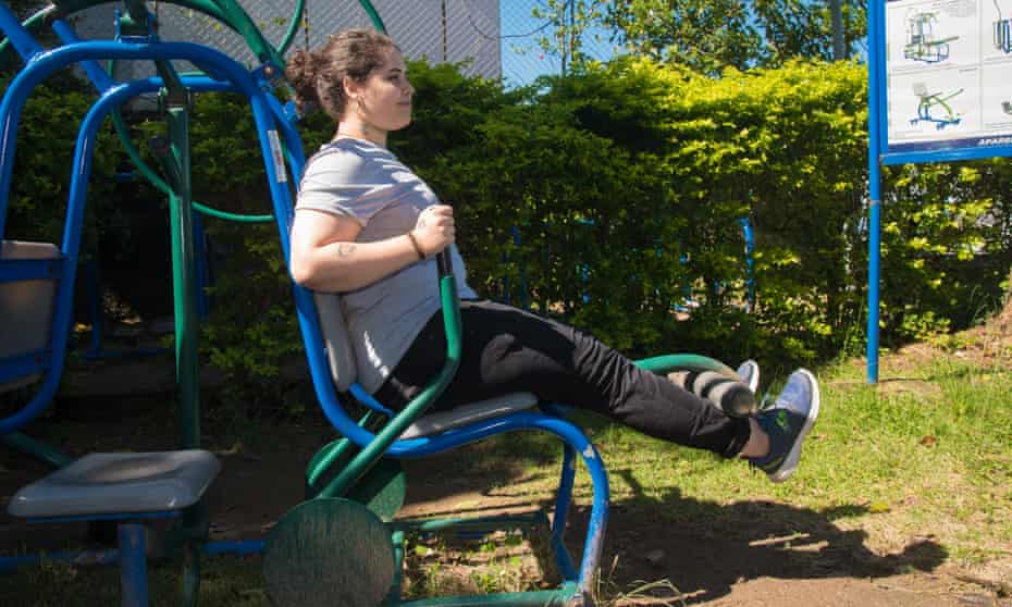 A woman works at an outdoor gym.