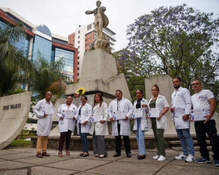 Nine Cuban doctors stand in front of a monument to Jose Marti during a farewell ceremomy in Guatemala City