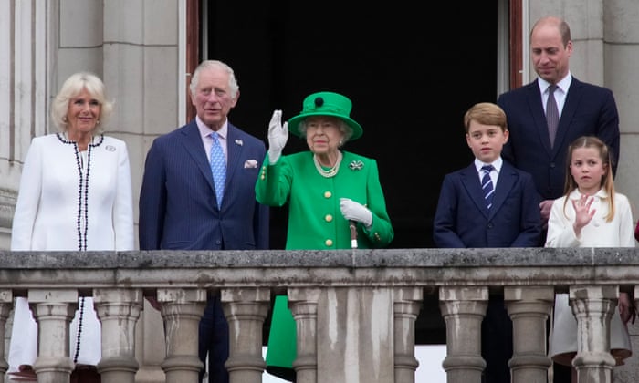 The Queen waves from the balcony of Buckingham Palace while wearing a green Stewart Parvin dress on Sunday.