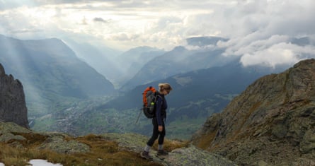 Young female backpacker on a hike up to mountain hut in autumn, moody day, Grindelwald, Berne Canton, Swiss Alps.