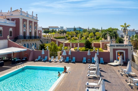 Swimming pool, trees and an attractive old hotel