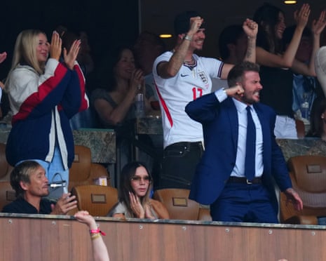 Victoria sits calmly in a private box while David, Harper and another Beckham all punch the air around her