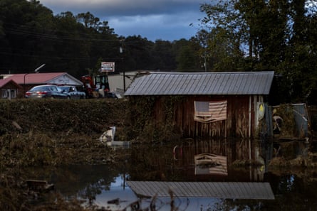 A building with a US flag hanging outside is surrounded by flooding.