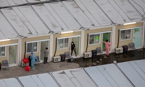 People stand outside their cabins at the Tsing Yi community isolation facility in Hong Kong