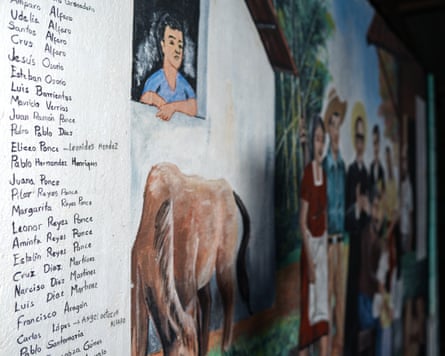 A list of dozens of names written on a wall next to a painting of rural people and a horse