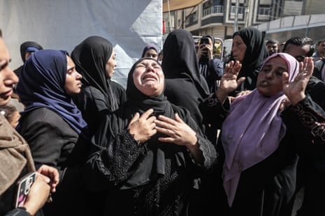 Relatives mourn near bodies of their loved ones killed by Israeli gunfire while they were waiting for aid in the Netzarim Corridor of the Gaza Strip on Tuesday.