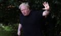 Boris Johnson wearing a black T-shirt, waving.