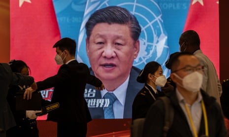 A video screen shows Chinese President Xi Jinping as security check visitors at the press centre for the 20th Congress of the Communist Party of China.