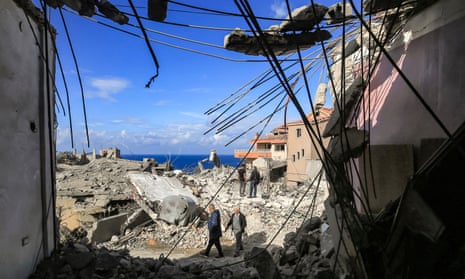 People walk past rubble and twisted steelwork