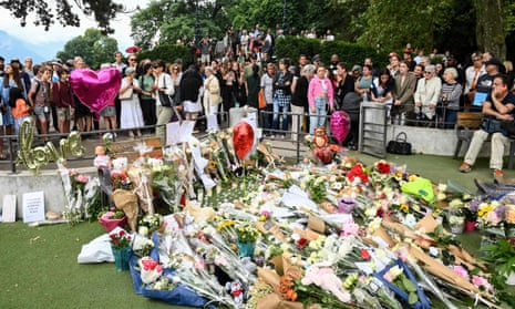 People gather on 9 June to lay flowers for the victims of a stabbing attack the day before in the Jardins de l'Europe parc in Annec