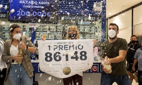 Workers of a lottery administration celebrate with champagne bottle