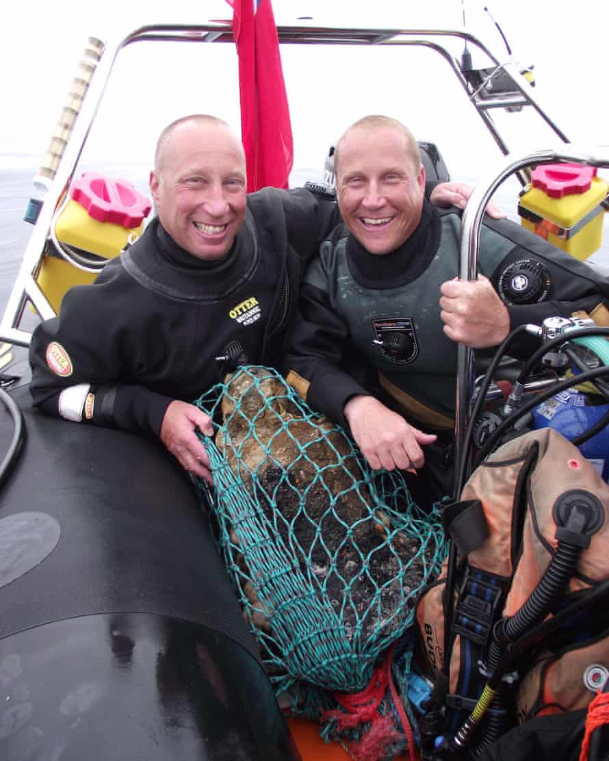 Brothers Julian and Lincoln Barnwell with with a bell from the wreck of the HMS Gloucester, that they located off the Norfolk coast.