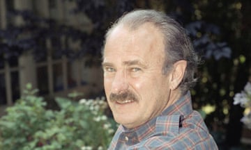 Man with black mustache in check shirt in garden