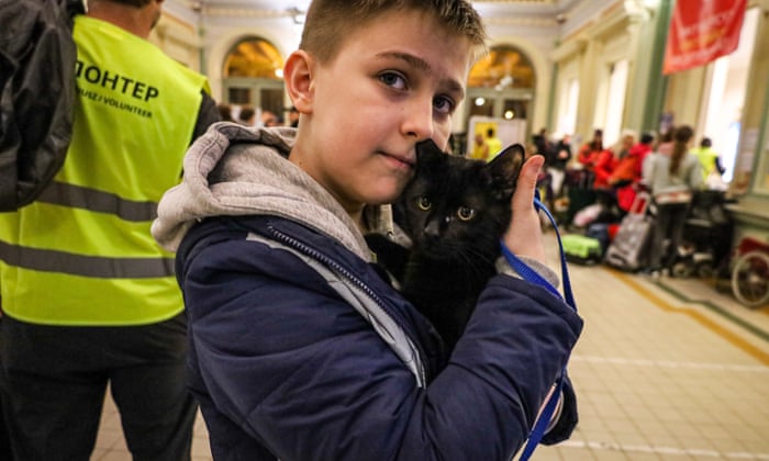 Bohdan lysun and his black cat Crowley late at night at the Przemyśl train station.
