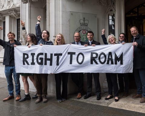 MPs and campaigners celebrate outside the supreme court in London holding a 'right to roam' banner