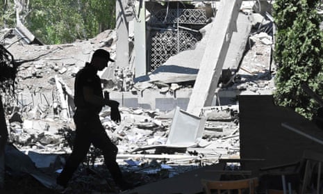 A Police expert walks among ruins of a school partially destroyed by a rocket in Kharkiv.