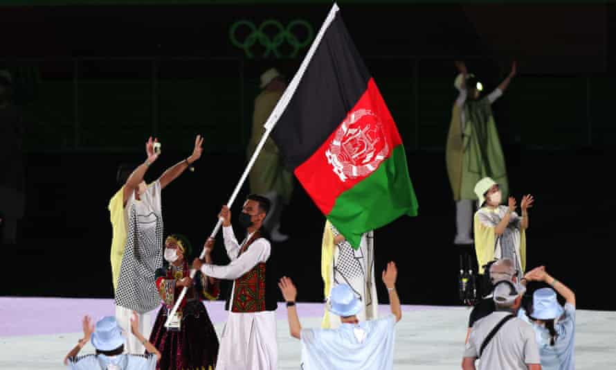 Farzad Mansouri and Kimia Yousofi carry the Afghanistan flag during the opening ceremony of the Tokyo Olympics