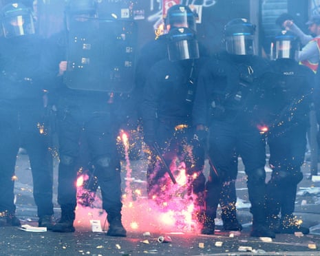 Fireworks mortar explode near French CRS riot police amid clashes with protesters in Paris.