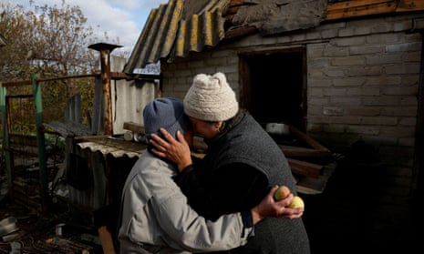 Nadia and a neighbour react as they walk through her home which was damaged in a missile strike near the Russian border in Kharkiv region, Ukraine.