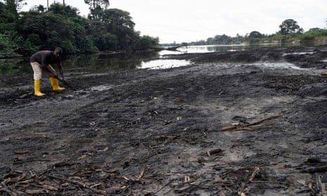 A farmer digs for crabs next to a river polluted by oil spills at B-Dere, Ogoniland in Rivers State, southern Nigeria, on 23 August 2021.