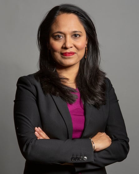 Rushanara Ali smiles slightly as she stands with arms folded